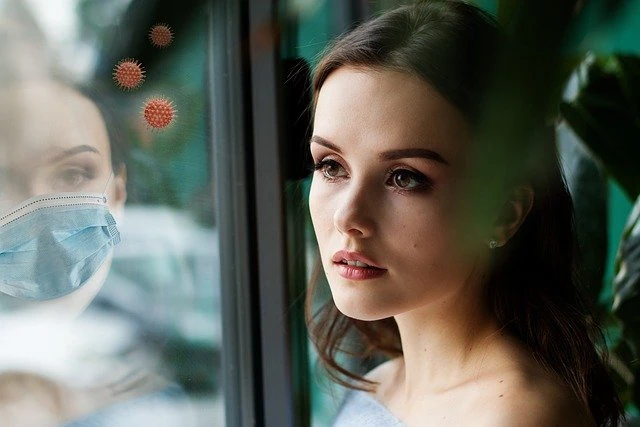 Imagen de mujer mirando por la ventana "LA BIOETICA LABORAL EN LA VUELTA AL TRABAJO TRAS EL COVID-19"