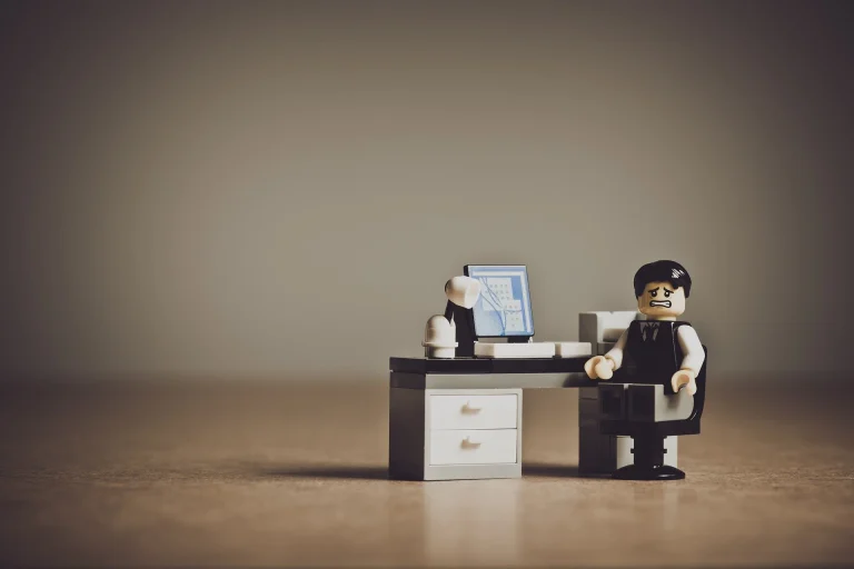 Imagen de un muñeco sentado delante de un ordenador